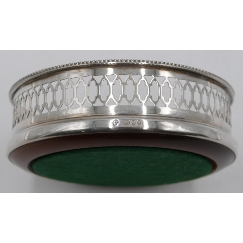 259 - A modern London silver wine coaster with pierced rim and wooden centre, 13cm diameter.