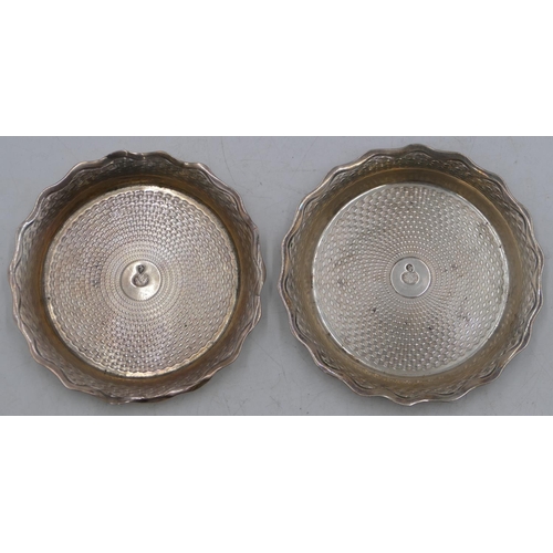 272 - A pair of Eastern silver-coloured metal round scallop shaped wine coasters with engine turn decorati... 