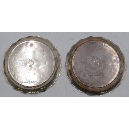 272 - A pair of Eastern silver-coloured metal round scallop shaped wine coasters with engine turn decorati... 