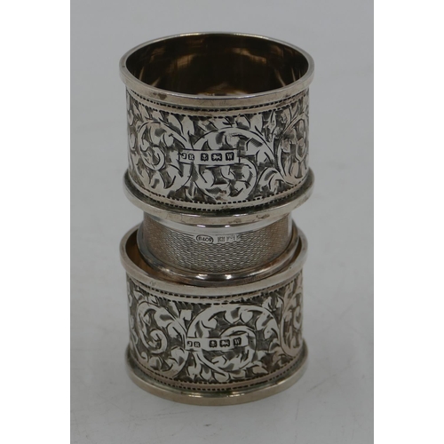 281 - A pair of Birmingham silver round napkin rings with allover chased leaf and scroll decoration and an... 