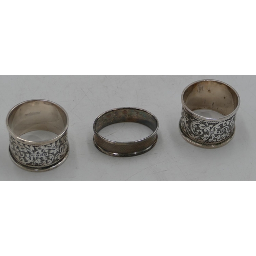 281 - A pair of Birmingham silver round napkin rings with allover chased leaf and scroll decoration and an... 