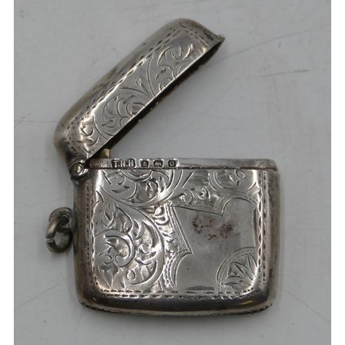 283 - A Birmingham silver concave shaped Vesta case with chased leaf and scroll decoration, hinged lid (sl... 