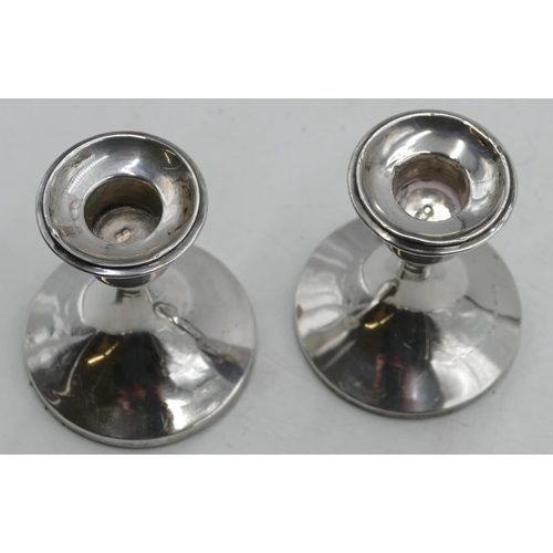 289 - A pair of Birmingham silver round dwarf candlesticks on sweeping bases (weighted), 9.5cm high.