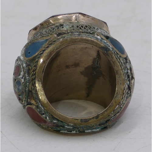 303 - Large Eastern style ring set with octagonal red stone with allover part enamelled decoration. Size X