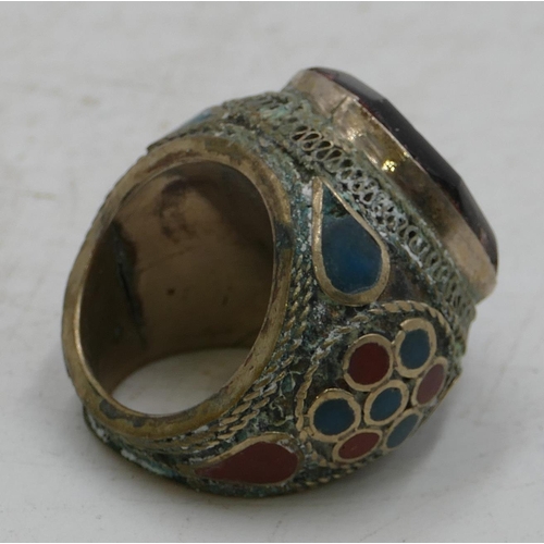 303 - Large Eastern style ring set with octagonal red stone with allover part enamelled decoration. Size X