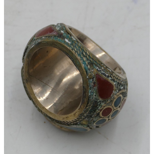 303 - Large Eastern style ring set with octagonal red stone with allover part enamelled decoration. Size X