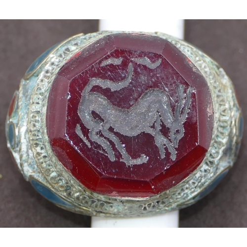 303 - Large Eastern style ring set with octagonal red stone with allover part enamelled decoration. Size X