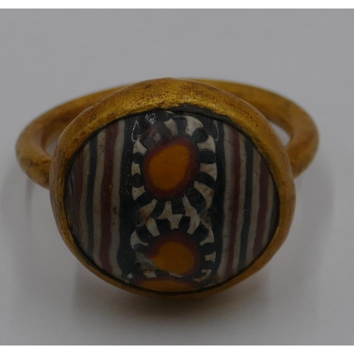 306 - A gilt ring with circular painted decoration. Size U/V