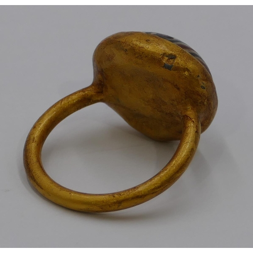 306 - A gilt ring with circular painted decoration. Size U/V