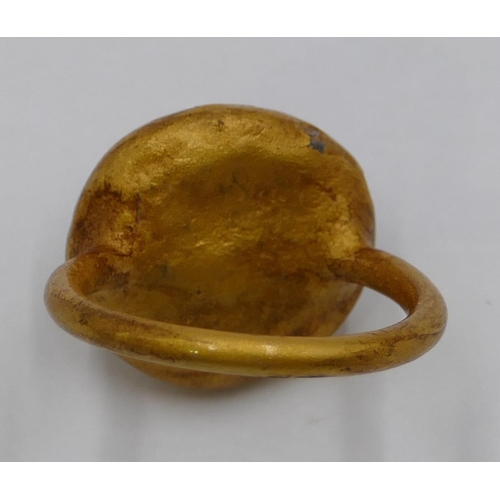 306 - A gilt ring with circular painted decoration. Size U/V