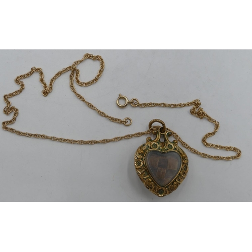 329 - A 9ct gold chain mounted with heart shaped mourning pendant with embossed decoration.