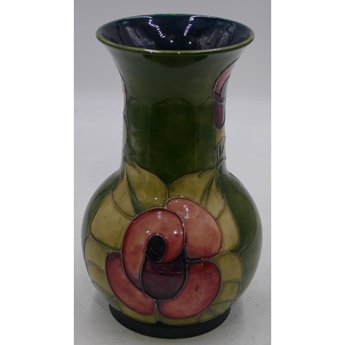 34 - A Moorcroft round bulbous thin necked trumpet shaped vase on green ground with coloured floral and l... 