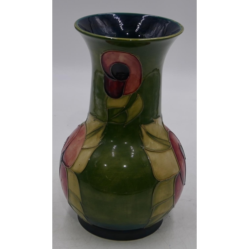 34 - A Moorcroft round bulbous thin necked trumpet shaped vase on green ground with coloured floral and l... 