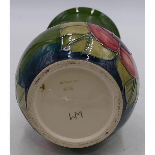 34 - A Moorcroft round bulbous thin necked trumpet shaped vase on green ground with coloured floral and l... 