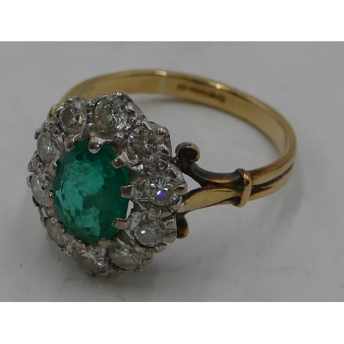 346 - An 18ct gold ladies' cluster ring set with centre emerald and surrounded by 10 diamonds, size N.