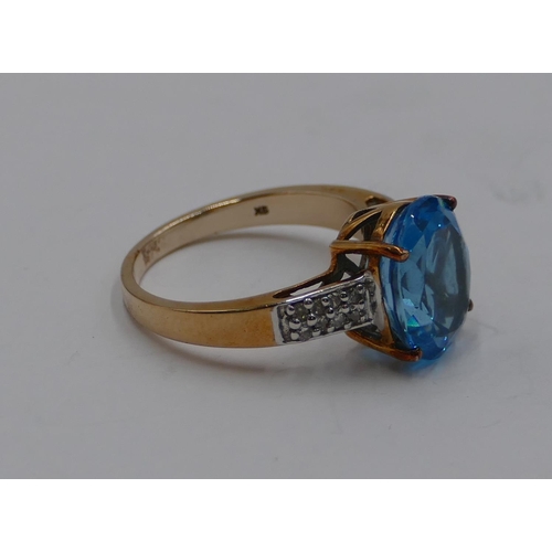 372 - A 9ct gold ladies' ring set with large aquamarine style stone and flanked by small diamond chips to ... 