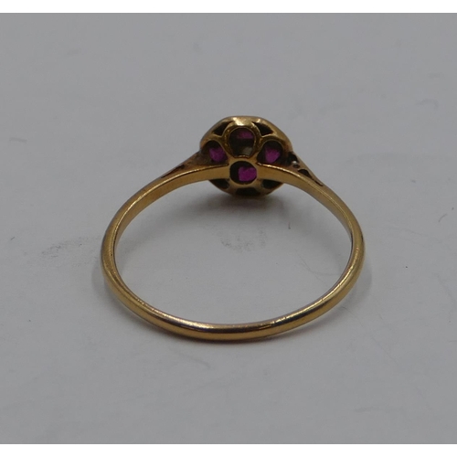 384 - An 18ct gold ladies' small circular ring set with 4 square cut rubies and interspersed with small di... 