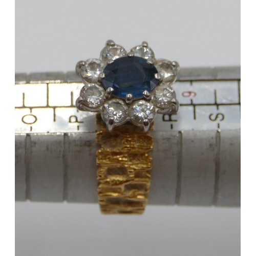 387 - An 18ct gold ladies' cluster ring set with centre oval sapphire and surrounded by 8 diamonds with sh... 