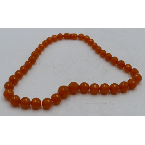 393 - An amber style graduated bead necklace, 49cm long.