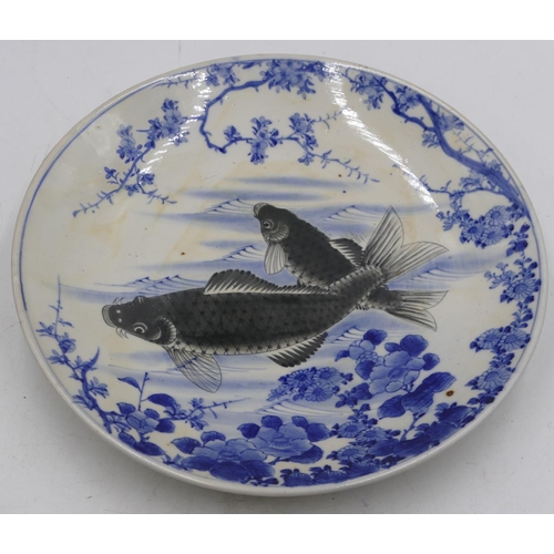 40 - An Oriental blue and white charger with black carp decoration, 31.5cm diameter