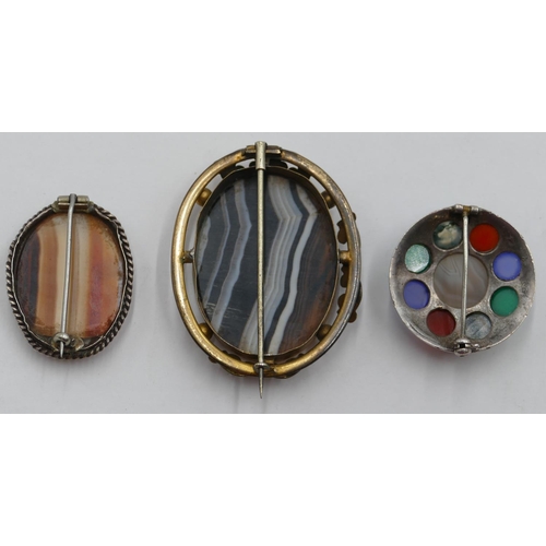 401 - An oval banded agate brooch, a smaller banded agate brooch and a circular brooch set with different ... 