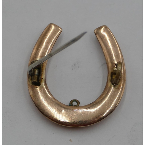 404 - A gold horse shoe  brooch with later metal pin, 2.7 grams gross.