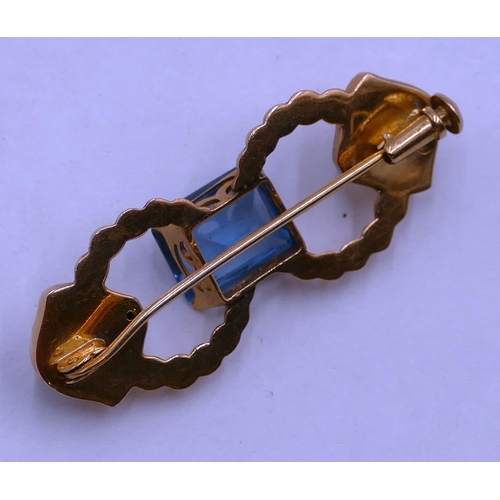 406 - A gold brooch set with centre aquamarine style stone, 3.7cm long, 4.2 grams gross.