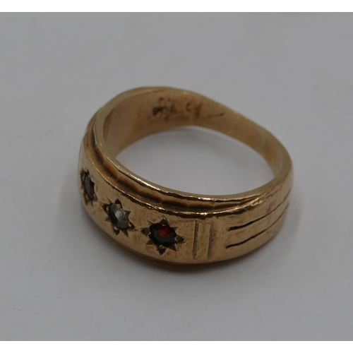 409 - A gold ring set with clear stone and flanked by 2 red stones, size O/P, 6.8 grams gross.