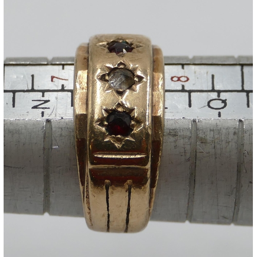 409 - A gold ring set with clear stone and flanked by 2 red stones, size O/P, 6.8 grams gross.