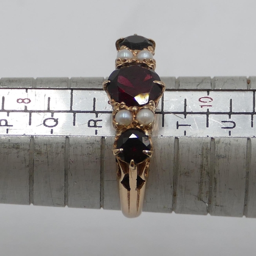 412 - A 9ct gold ladies' ring set with 3 garnets interspersed by 4 small half pearls, size S, 3.9 grams gr... 