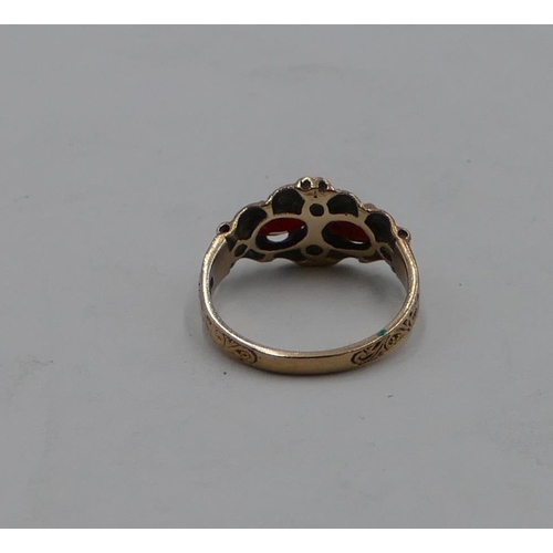 414 - A 9ct gold small ladies' ring set with 2 garnets interspersed by small half pearls, size M, 2.5 gram... 