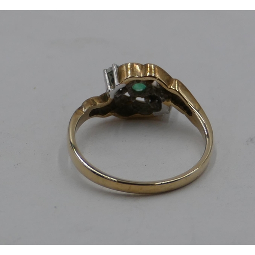 417 - A 9ct gold ladies' twist ring set with centre small emerald and flanked by 2 small diamonds, size P,... 