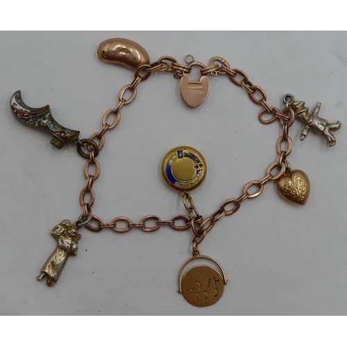 428 - A 9ct gold bracelet mounted with 7 charms (3 not gold), 14.9 grams gross.