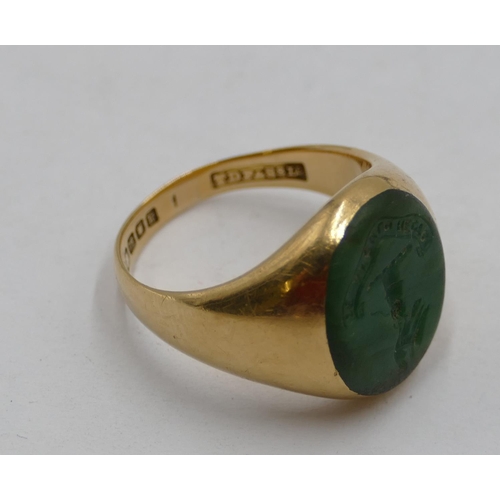 440 - An 18ct gold oval ring set with green intaglio depicting crest, size P, 13.4 grams.