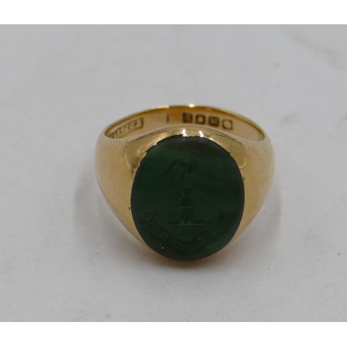 440 - An 18ct gold oval ring set with green intaglio depicting crest, size P, 13.4 grams.