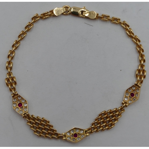 441 - An 18ct gold bracelet mounted with 3 panels, inset with small rubies coloured stones surrounded by c... 