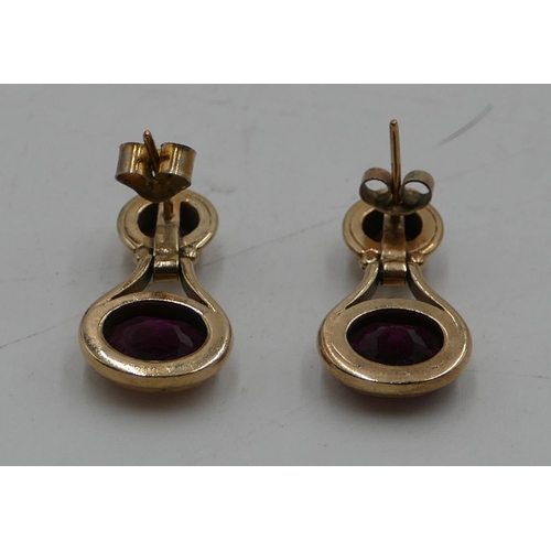 499 - A pair of 9ct gold drop earring mounted with purple stones, 6.7 grams gross.