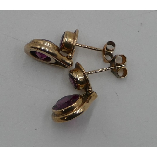 499 - A pair of 9ct gold drop earring mounted with purple stones, 6.7 grams gross.