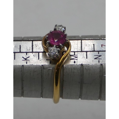 513 - An 18ct gold twist ring with centre ruby flanked by 2 small diamonds, size L. 2.9 grams.