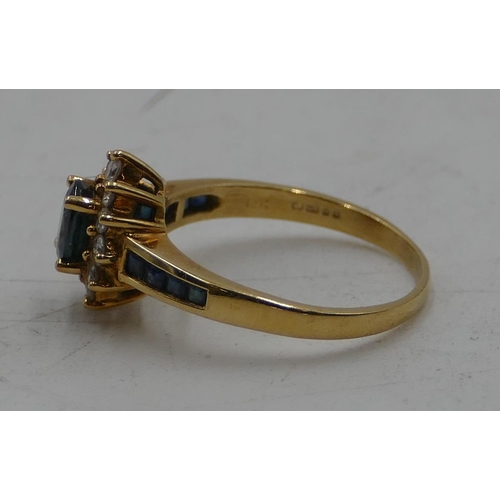 514 - An 18ct gold ladies' oval cluster ring set with centre sapphire and surrounded by 12 small diamonds ... 