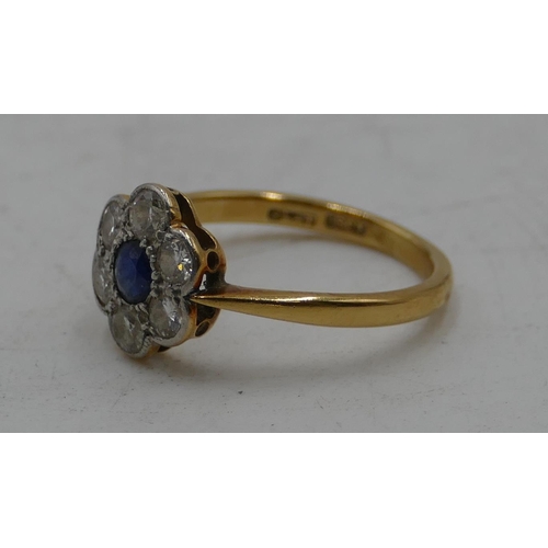 517 - An 18ct gold ladies' circular cluster ring with centre sapphire and flanked by 6 diamonds, size M, 2... 