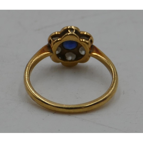 517 - An 18ct gold ladies' circular cluster ring with centre sapphire and flanked by 6 diamonds, size M, 2... 