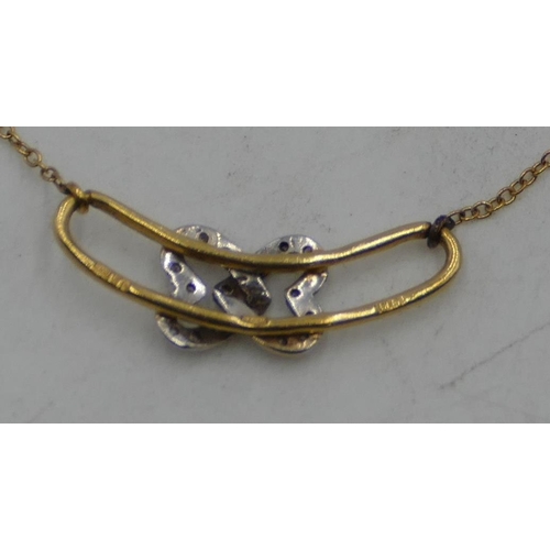 518 - An 18ct gold drop pendant with entwined parts, inset with small diamonds, with chain, 38cm long, 3.2... 