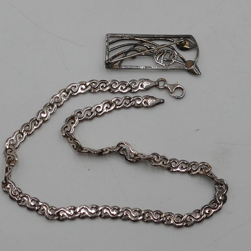 525 - A modern Carrick brooch in the style of Rennie Mackintosh (boxed) and a silver flat chain. (2)