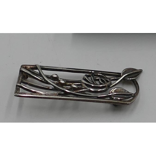 525 - A modern Carrick brooch in the style of Rennie Mackintosh (boxed) and a silver flat chain. (2)