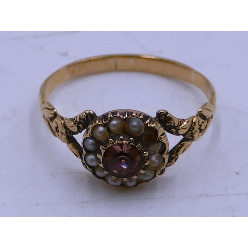 540 - A Victorian gold ladies' cluster ring set with centre pink stone surrounded by half pearls (2 pearls... 