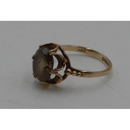 550 - A 9ct gold ladies' smoky quartz ring with pierced rim, size L/M, 2.1 grams gross.