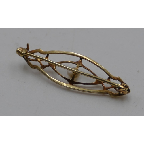 552 - A small 14ct gold brooch with pierced decoration and mounted with centre pearl, 3.2cm long, 1.3 gram... 