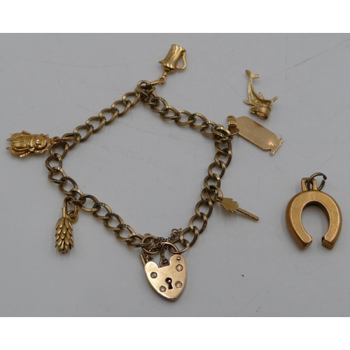 556 - A 9ct gold linked bracelet with padlock clasp, mounted with 7 14ct gold and higher charms (2 charms ... 