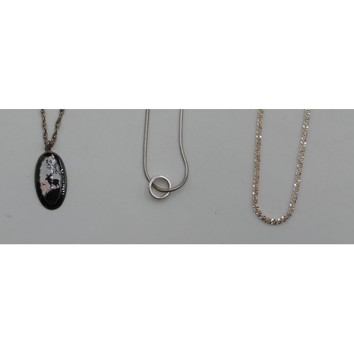 559 - An oval silver and enamelled pendant with deer motif with silver chain, a snake linked chain with sm... 